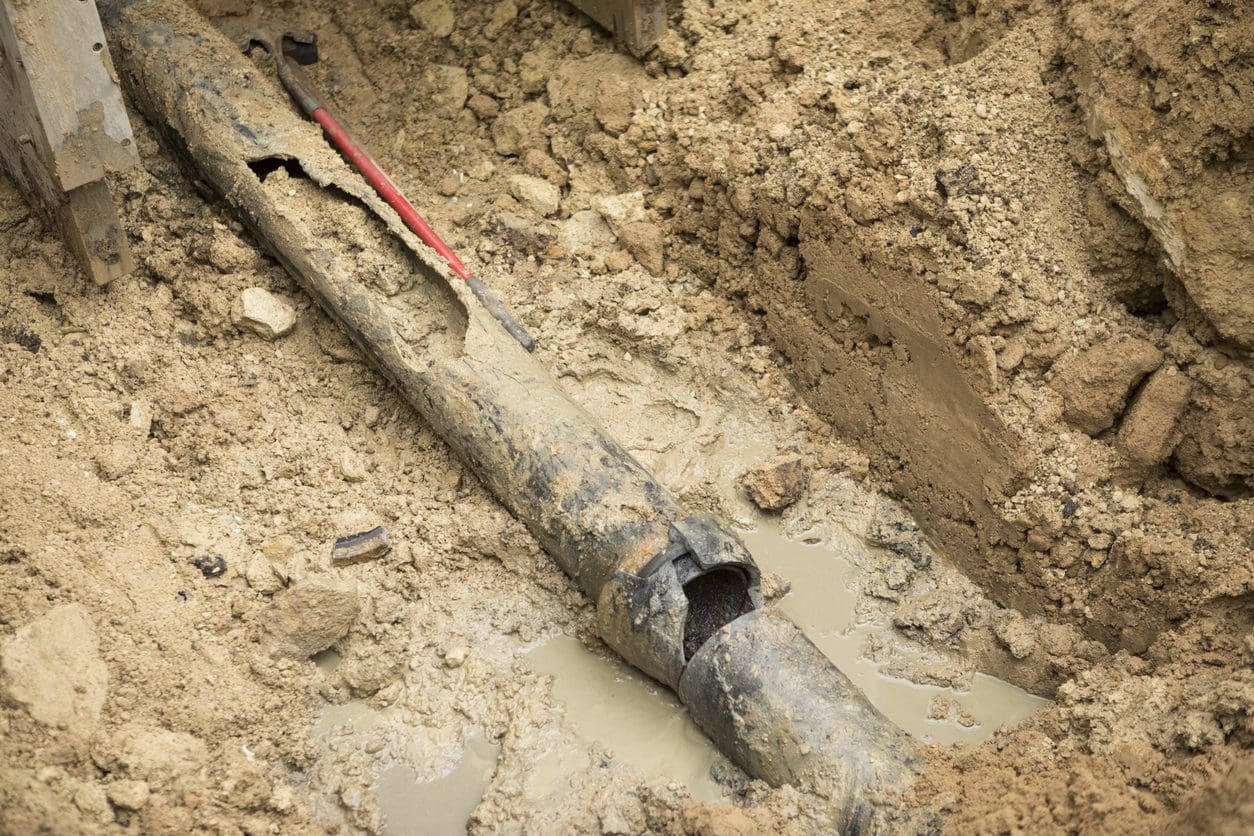 A broken water main pipe dug underground to be replaced.